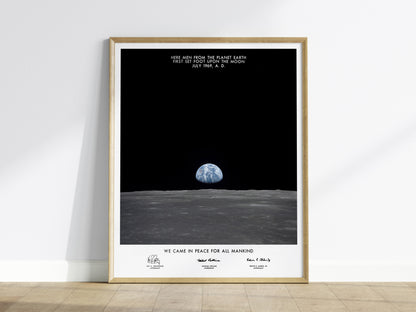 Framed Apollo 11 Earth on the Horizon wall art hanging on a white wall in a modern living room