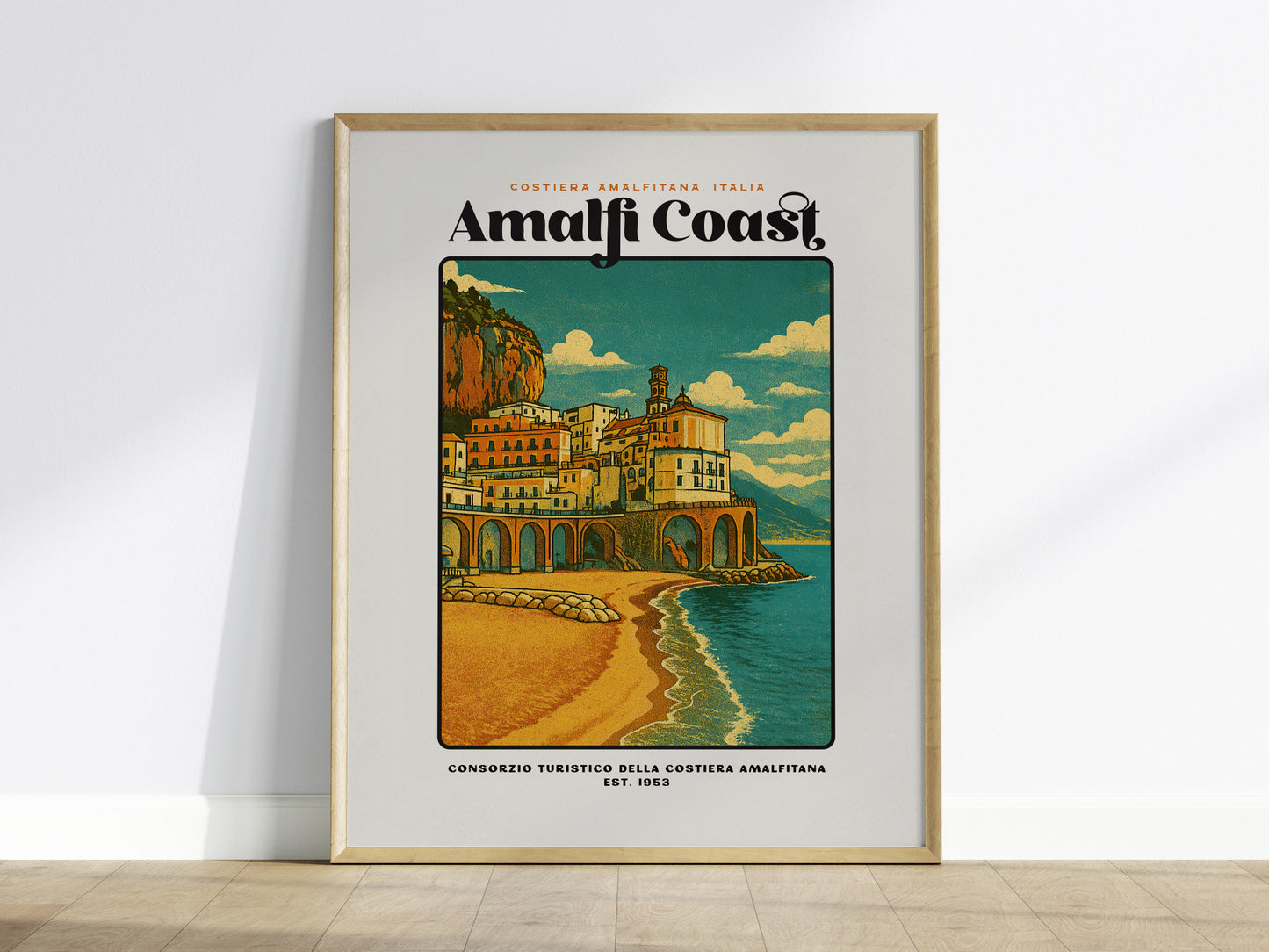 Framed Amalfi Coast Italy travel poster hanging above a sofa in a modern living room