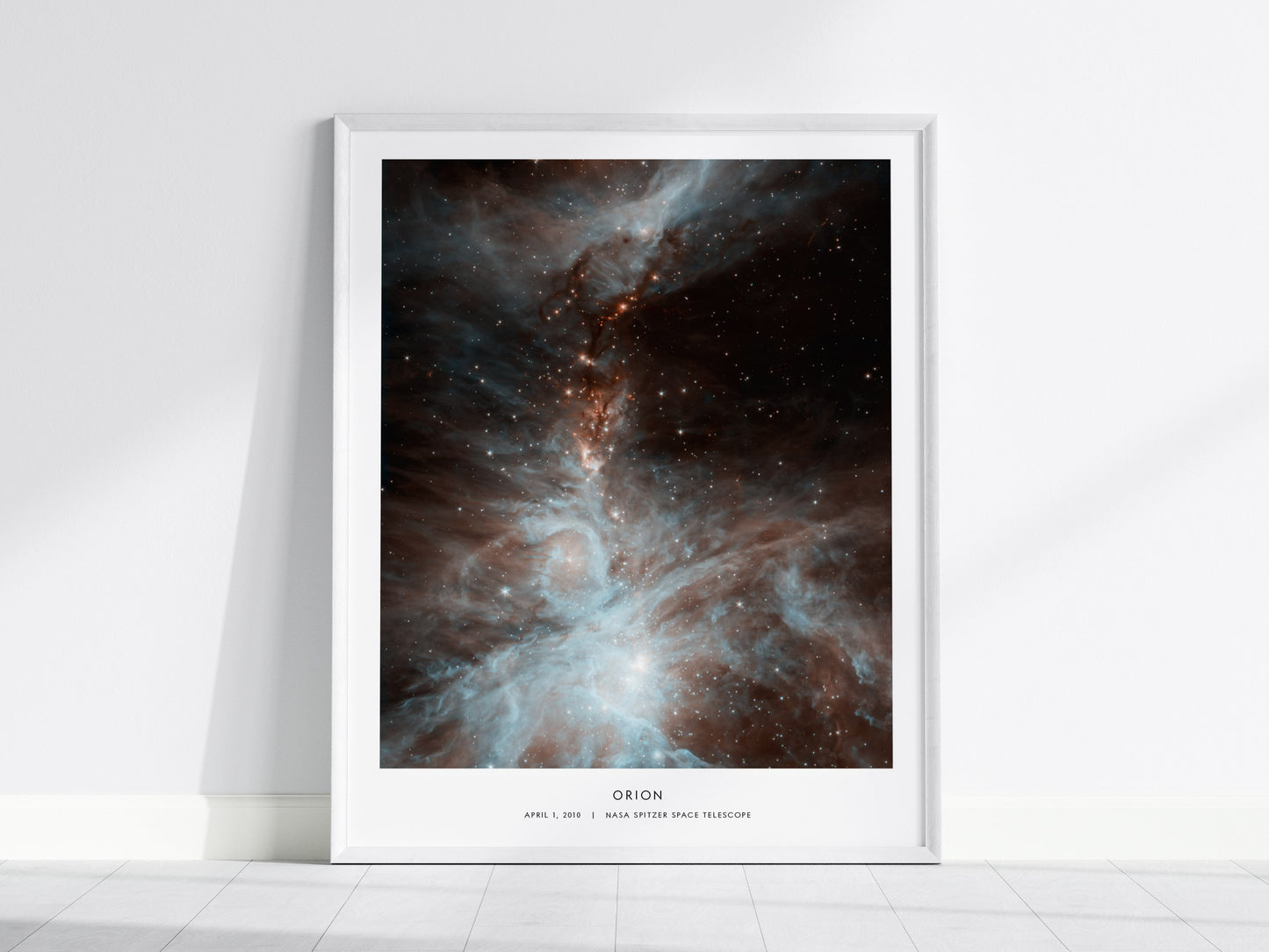 Framed poster of the Orion Nebula on a white wall