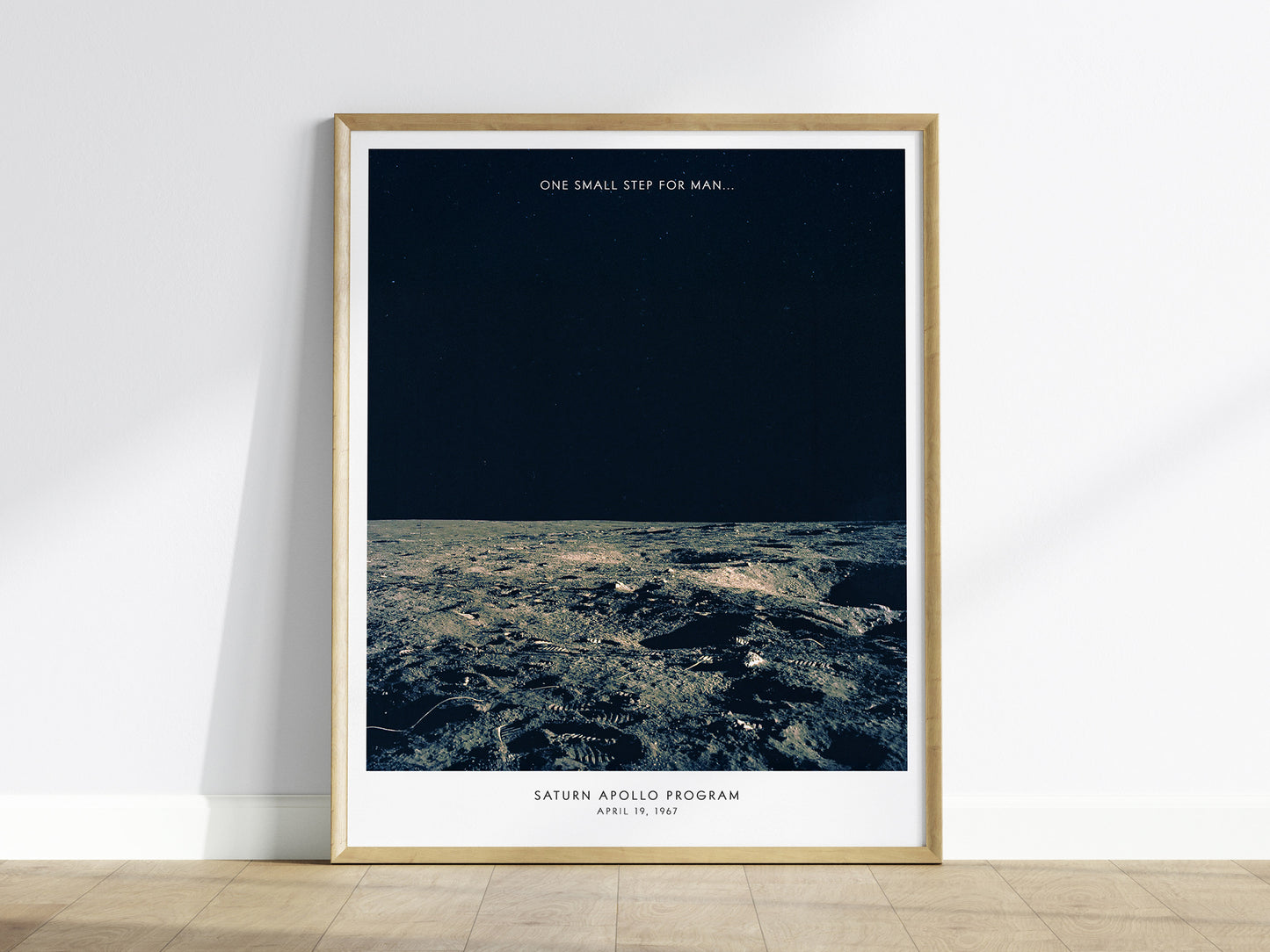Framed poster of Apollo 12 Moon Landing with text on a white wall.