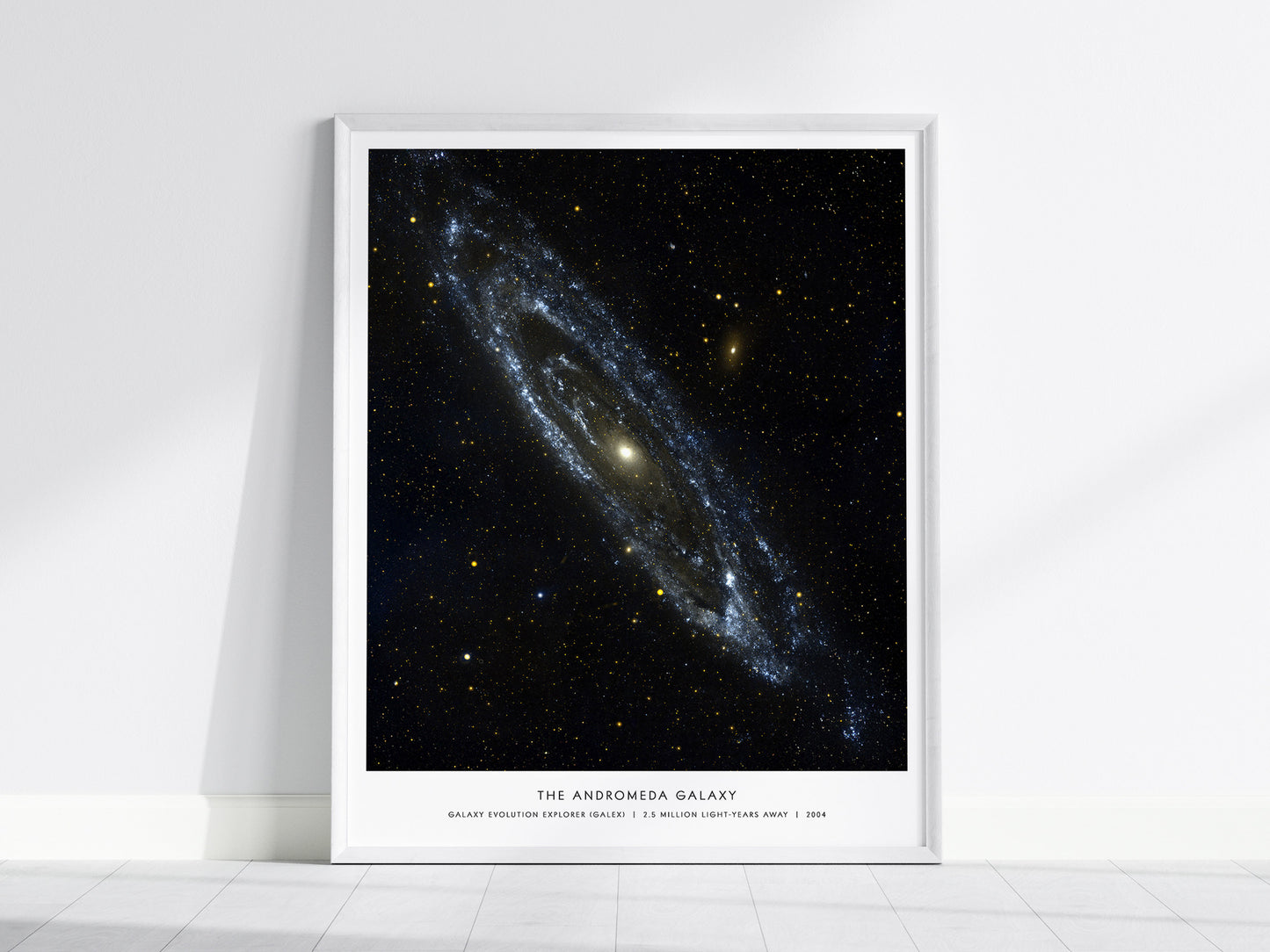 Framed poster of the Andromeda Galaxy on a white wall.