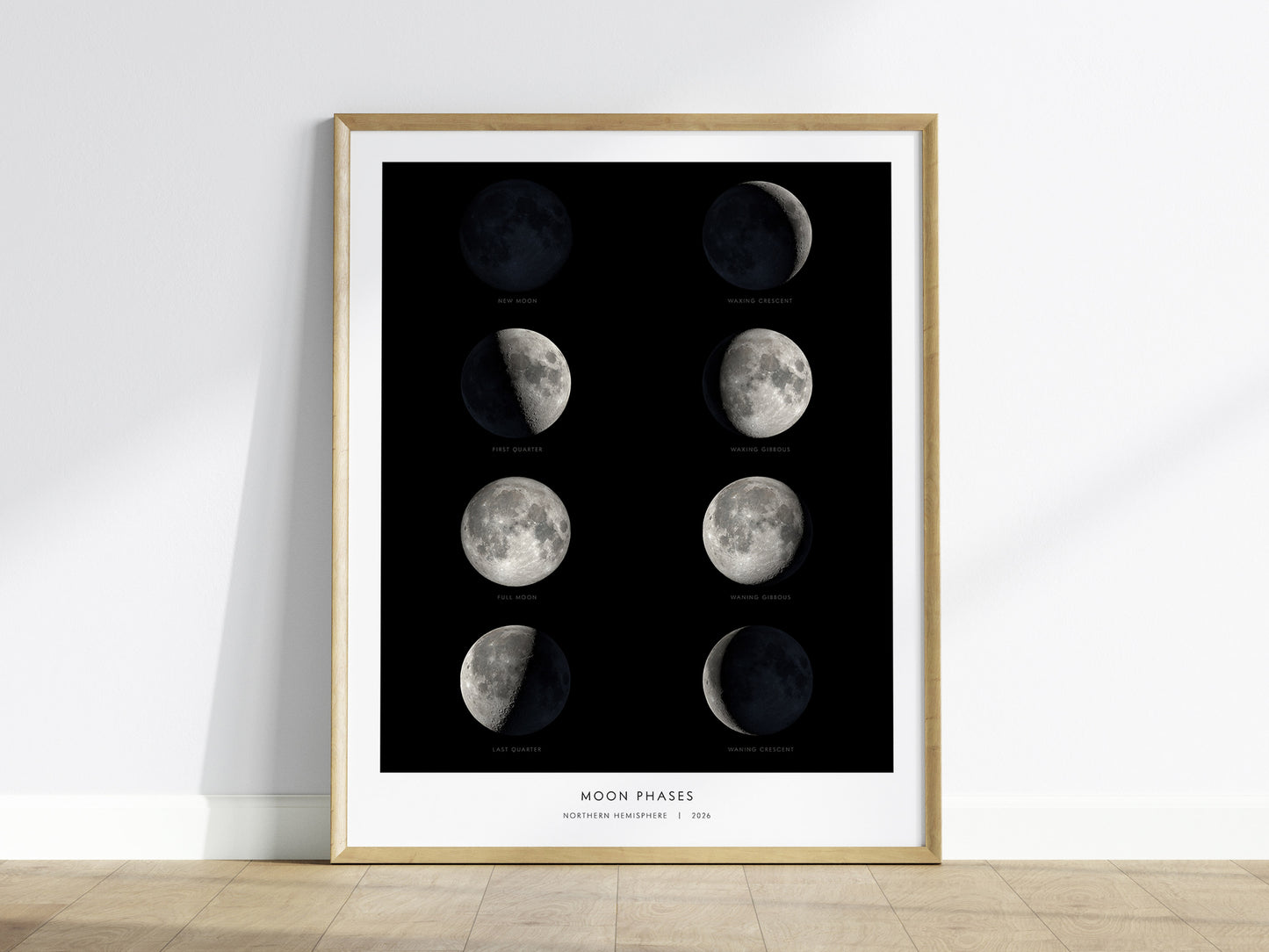 A framed poster featuring the eight phases of the moon, displayed in a grid format against a black background. Each phase, from new moon to waning crescent, is labeled and illustrated with detailed NASA photography.