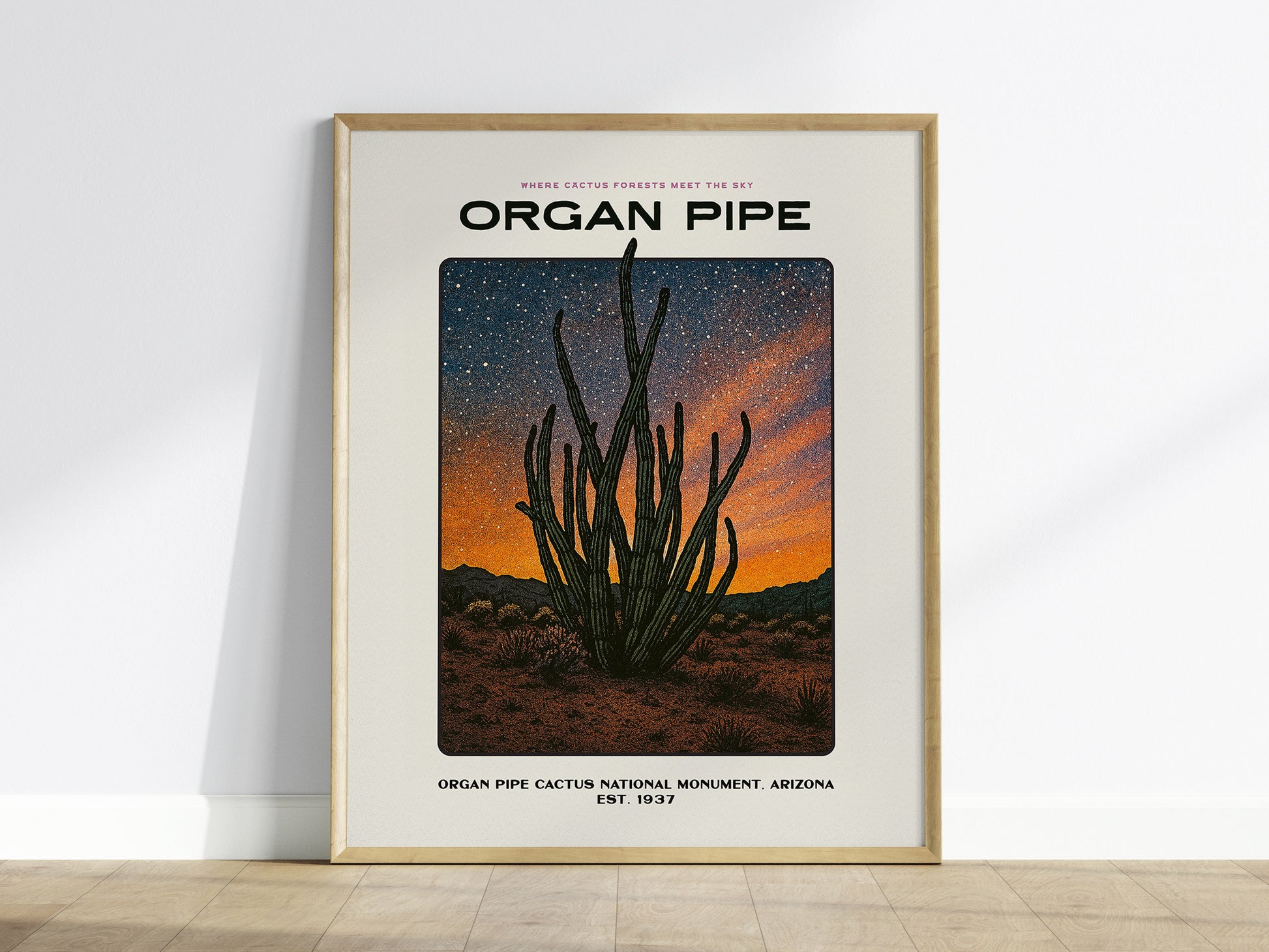 Framed poster of Organ Pipe Cactus National Monument with a cactus illustration against an orange sunset sky.