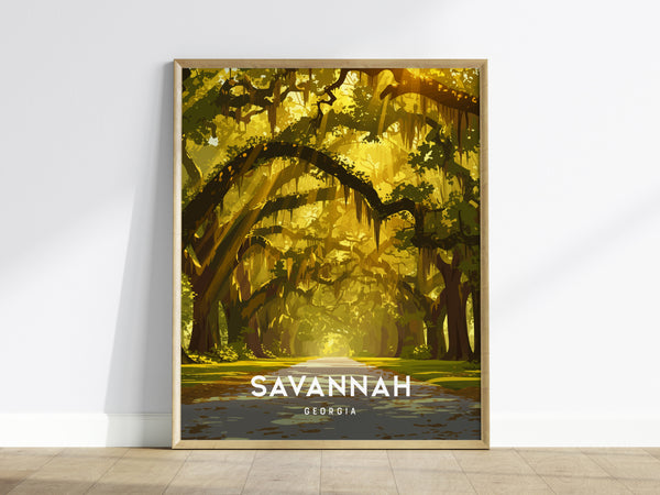 A framed poster on a wooden floor shows a tree-lined avenue draped in live oaks and Spanish moss, bathed in warm golden light. The text SAVANNAH GEORGIA is prominently displayed at the bottom.