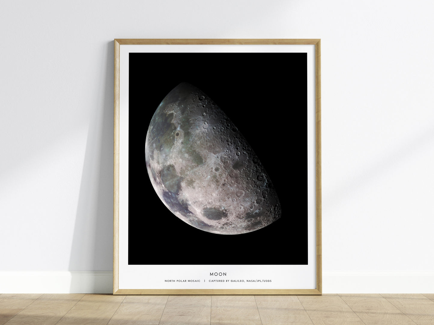 Framed print of the moon's surface on a white wall.