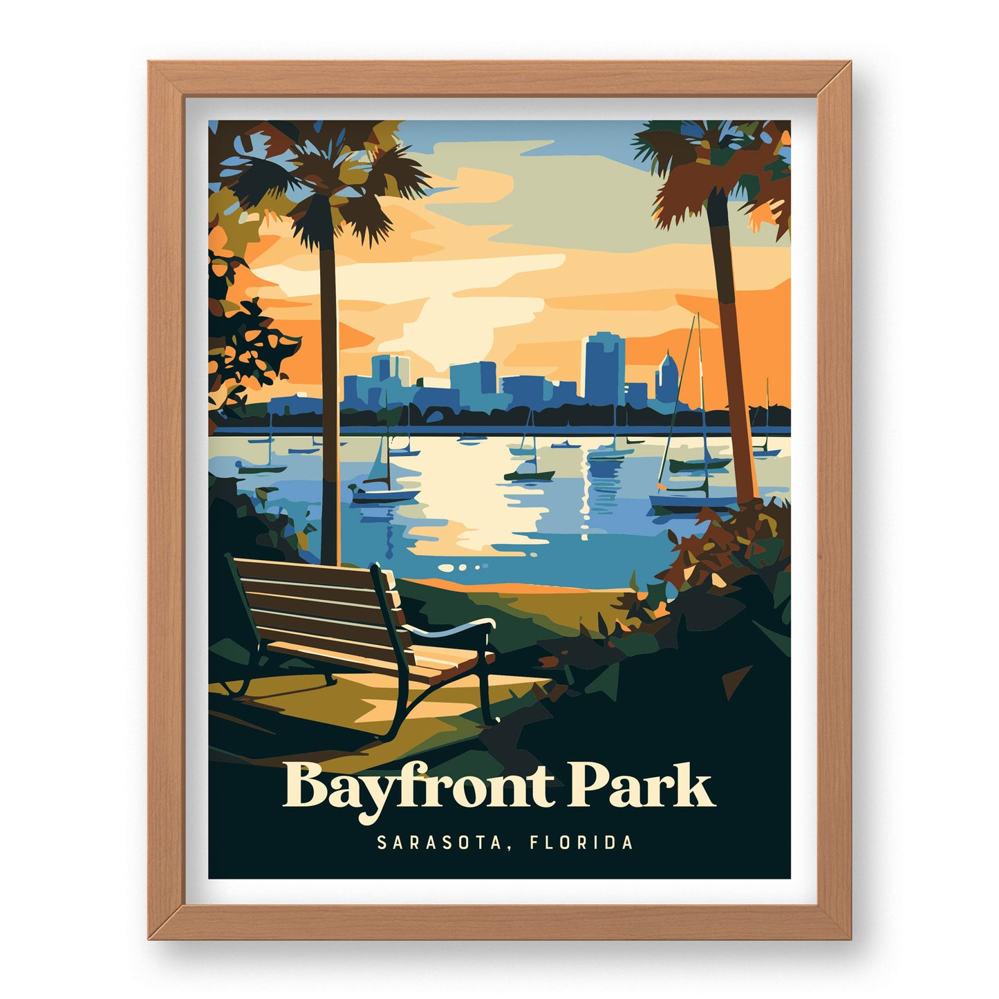 Framed artwork depicting a tranquil scene of Bayfront Park in Sarasota, Florida. A bench faces a calm bay with sailboats and a city skyline in the background, framed by palm trees against a vibrant sunset sky.