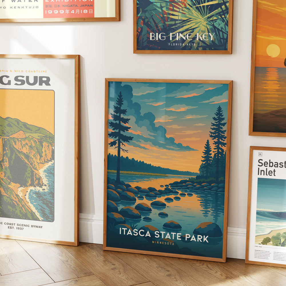 A beautifully framed print of Itasca State Park in Minnesota, showcasing a serene landscape with a calm lake, rocky shoreline, and tall pine trees under a colorful sunset sky.