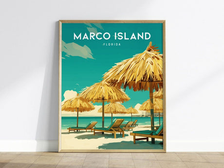 Framed poster of Marco Island, Florida, showing sandy beach with straw umbrellas and lounge chairs against a turquoise sea and sky backdrop. Text reads Marco Island Florida.