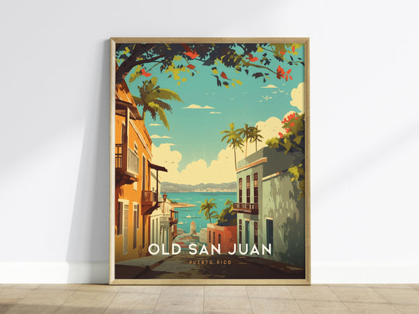 A framed poster of Old San Juan rests against a white wall, depicting a colorful street scene with pastel buildings, palm trees, and a view of the ocean. The vibrant artwork captures the essence of Puerto Rico.