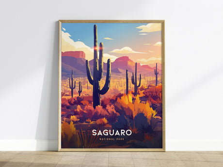 A framed poster of Saguaro National Park shows a vibrant desert landscape with towering saguaro cacti under a colorful sunset sky. The scene includes distant mountains and lush desert foliage, capturing the essence of Arizonas beauty.