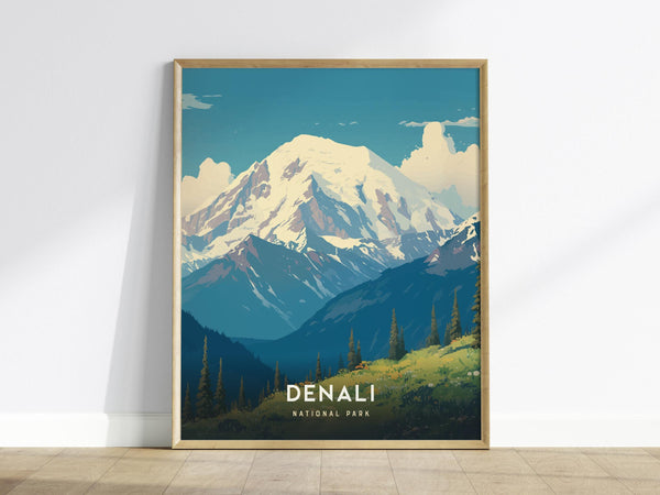 A framed poster of Denali National Park is displayed against a white wall. The artwork features snow-covered peaks under a blue sky, with green valleys and pine trees in the foreground. The word Denali is prominently visible.