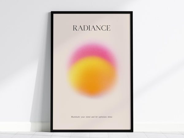 A framed poster titled RADIANCE features a vibrant pink and yellow gradient circle on a light background. The text at the bottom reads, Illuminate your mind and let optimism shine. The poster leans against a white wall.