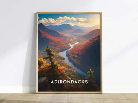 A framed poster depicting the Adirondacks in New York, showcasing a vibrant landscape with colorful fall foliage, a winding river, and majestic mountains under a cloudy sky. The words The Adirondacks New York are visible at the bottom.
