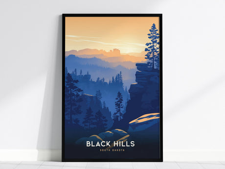 A framed art print depicting the Black Hills in South Dakota, showcasing a landscape with layered blue ridges and silhouetted trees under a gradient sky of golden hues. The words Black Hills South Dakota are visible at the bottom.