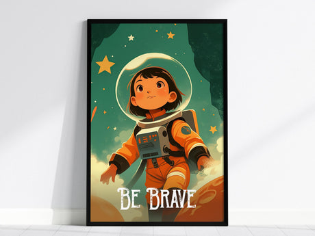 A framed illustration of a young astronaut in an orange suit, gazing upward in a starry space setting with planets and stars. The words Be Brave are prominently displayed at the bottom, inspiring courage and exploration.