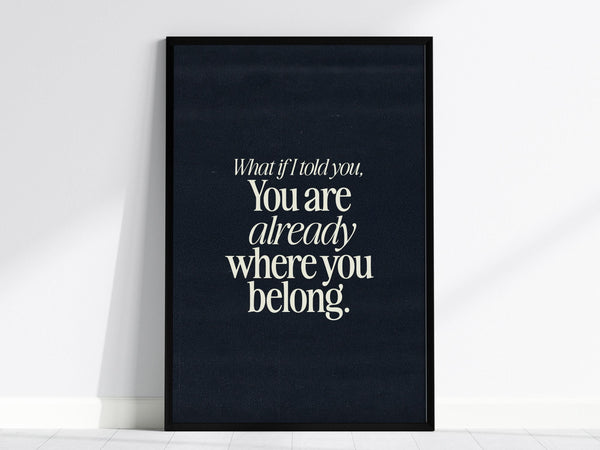 A framed poster with the quote What if I told you, You are already where you belong in elegant white typography on a dark background. This wall art piece promotes mindfulness and self-acceptance.