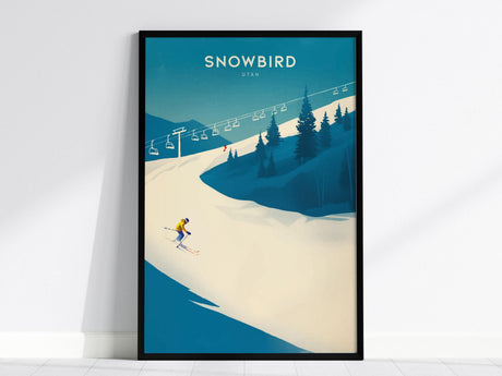A framed poster displays a skier in a yellow outfit navigating a snowy slope under a clear blue sky, with pine trees and ski lifts in the background. The word Snowbird is prominently featured at the top.