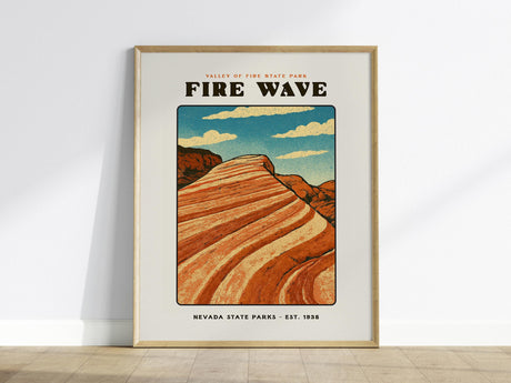 A framed poster of the Fire Wave at Valley of Fire State Park, featuring vibrant orange and red swirling rock formations under a blue sky with clouds. The text reads Valley of Fire State Park - Fire Wave - Nevada State Parks - Est. 1935.