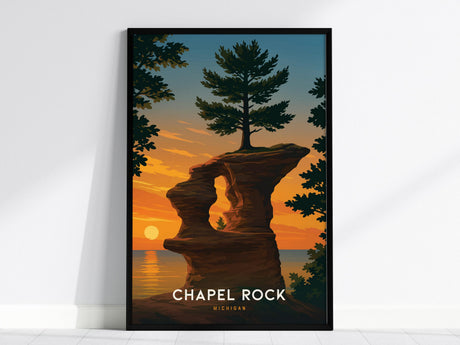 A framed poster of Chapel Rock in Michigan features a vibrant illustration of a sandstone formation and a solitary pine tree against a sunset sky over Lake Superior. The text at the bottom reads Chapel Rock Michigan.