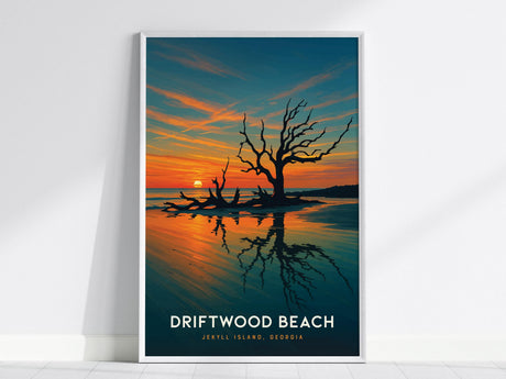 A framed poster depicting Driftwood Beach on Jekyll Island, Georgia, features a dramatic sunset with vibrant orange and blue hues. Silhouetted driftwood trees rise from the sand, creating a striking reflection on the water.