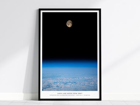 Framed poster of Earth and Moon from orbit on a white wall