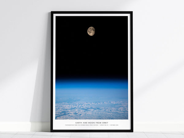Framed poster of Earth and Moon from orbit on a white wall