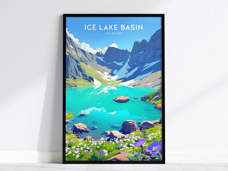 A framed poster of Ice Lake Basin in Colorado, showcasing vibrant turquoise alpine water surrounded by rugged peaks and lush meadows with wildflowers. The scene is set against a bright blue sky.