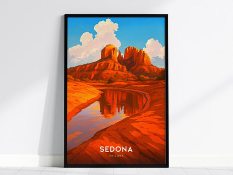 A framed poster features a vibrant illustration of Sedonas iconic red rock formations reflected in a serene river, under a bright blue sky with fluffy clouds. The bottom of the poster reads Sedona Arizona.