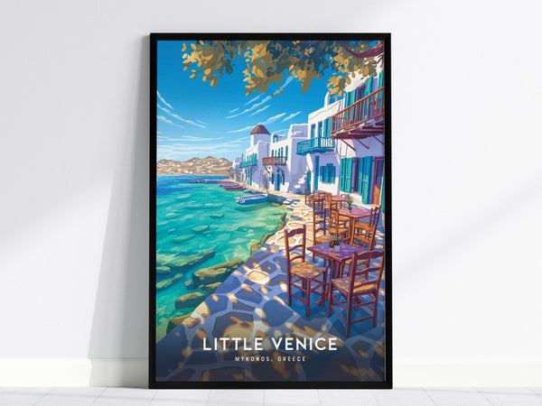 The framed poster depicts a vibrant seaside scene in Little Venice, Mykonos, featuring whitewashed buildings with colorful balconies, a clear blue sky, and turquoise waters. Wooden chairs and tables line a stone pathway under lush trees.