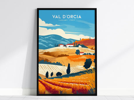 This image shows a framed poster of the Val dOrcia landscape in Tuscany, Italy. It features vibrant illustrations of rolling hills, cypress trees, and rustic farmhouses under a blue sky.