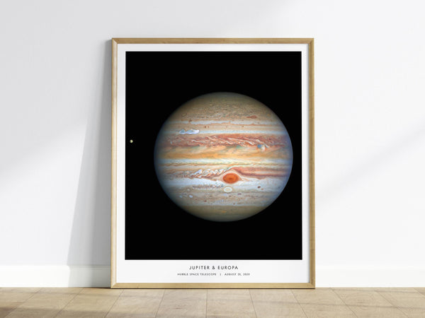 Framed poster of Jupiter and Europa on a white wall.
