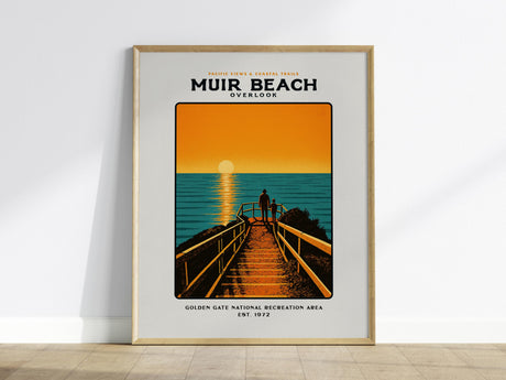 A framed poster of Muir Beach Overlook features a vibrant illustration of a sunset over the ocean, with two figures walking on a wooden path. The text highlights the Golden Gate National Recreation Area.