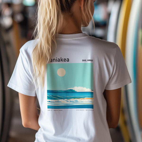 Person wearing a white Laniakea t-shirt with a graphic design on the back, featuring text and a landscape.