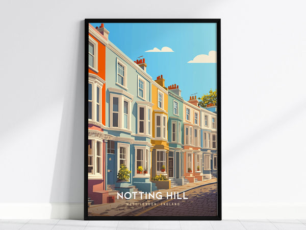 A framed poster depicts a row of colorful, pastel townhouses along a cobblestone street under a blue sky with clouds. The artwork is titled Notting Hill and rests against a white wall.