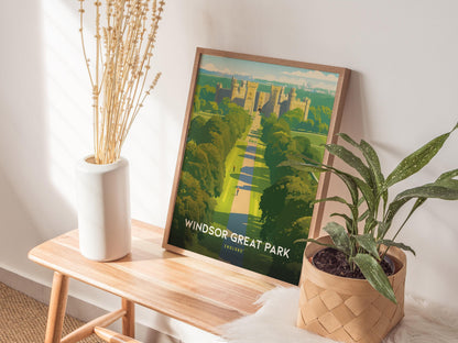Framed poster of Windsor Great Park on a wooden table with plants and a vase.