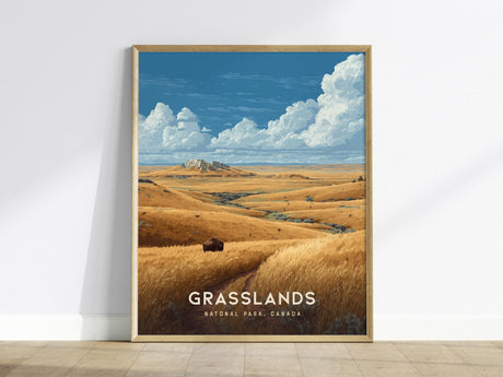 Framed poster depicting Grasslands National Park in Canada, featuring golden hills under a blue sky with fluffy clouds and a solitary bison in the foreground. The artwork captures the vast prairie landscape.