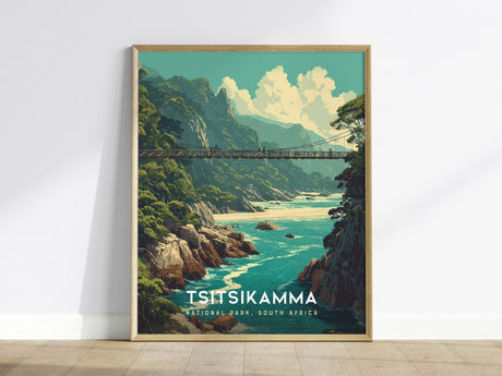 A framed poster of Tsitsikamma National Park showcasing a suspension bridge over rugged cliffs and turquoise waters, surrounded by lush green forests under a partly cloudy sky. The text reads Tsitsikamma National Park, South Africa.