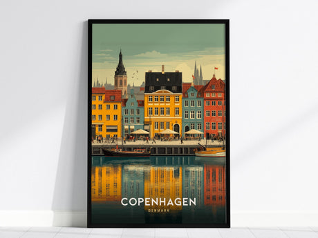 A framed poster of Copenhagens Nyhavn Harbor features colorful buildings and sailboats reflecting in the water. The lively scene captures the charm of the iconic canal area with a clear sky above.