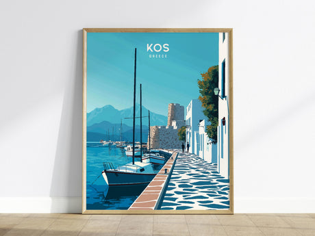A framed poster of Kos, Greece, features a serene harbor scene with sailboats, whitewashed buildings, and a stone pathway. The backdrop includes a medieval castle and distant mountains under a clear blue sky.