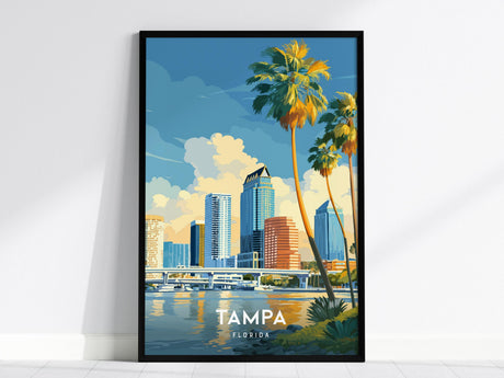 A framed poster of Tampa, Florida, features a vibrant illustration of the citys skyline with towering palm trees in the foreground. The scene captures reflections of high-rises in the water under a bright, blue sky.