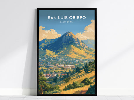 Framed poster of San Luis Obispo, featuring Bishop Peak under a blue sky with fluffy clouds. The vibrant illustration showcases rolling golden hills and lush greenery, capturing the scenic beauty of Central Coast California.