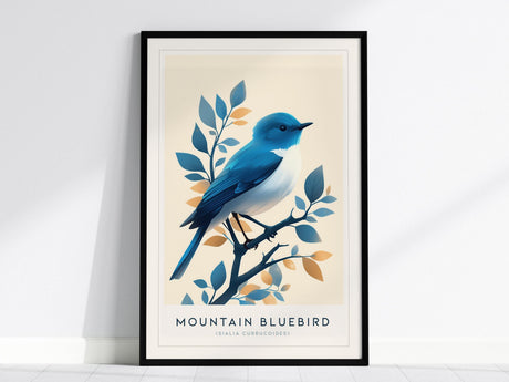 A framed poster displays a vibrant bluebird perched on a branch with stylized blue and orange leaves. The artwork is in a modern vintage style against a light beige background, titled Mountain Bluebird.