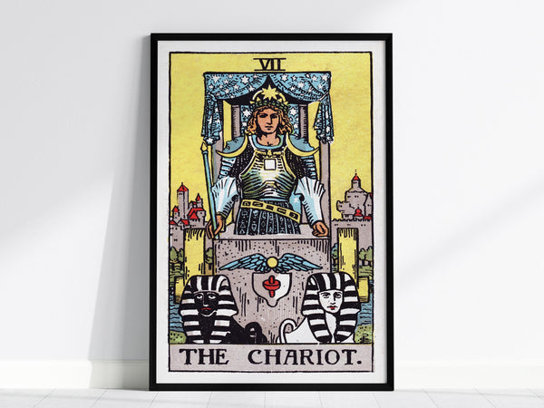 The image shows a framed poster of The Chariot tarot card from the Rider Waite deck, featuring a figure in armor with a crown, holding a wand, and two sphinxes at the base. The background is a vibrant yellow.