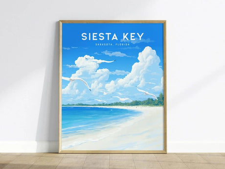 A vibrant poster featuring Siesta Key Beach, showcasing a bright blue sky with fluffy white clouds above a serene shoreline. The artwork captures the essence of the beach with soft sand and gentle waves, framed in a light wooden border.