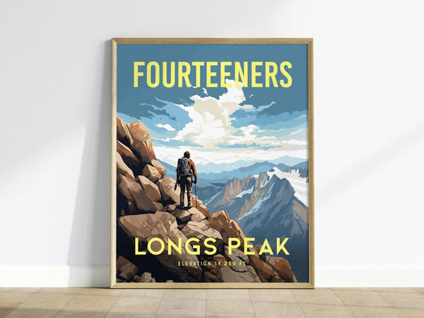 A framed poster depicting a hiker on rocky terrain overlooking mountains, with the words Fourteeners and Longs Peak Elevation 14,259 ft in bold yellow text.