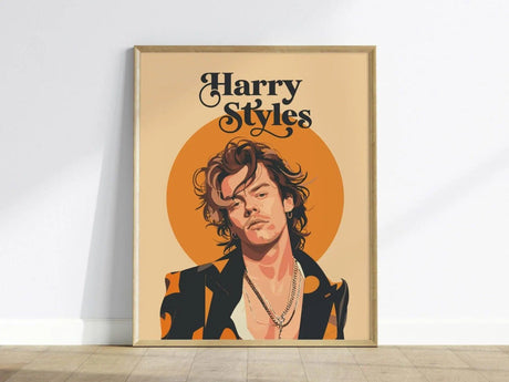 Illustrated poster of a man with layered necklaces and a patterned jacket, set against an orange circle background, framed on a wooden floor. Text reads Harry Styles.