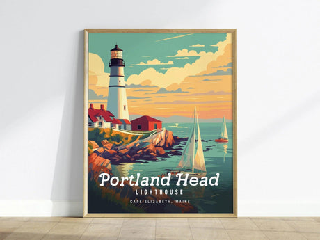 Framed poster of Portland Head Lighthouse showing a white tower and red-roofed buildings on rocky cliffs with sailboats on a colorful ocean under a partly cloudy sky.