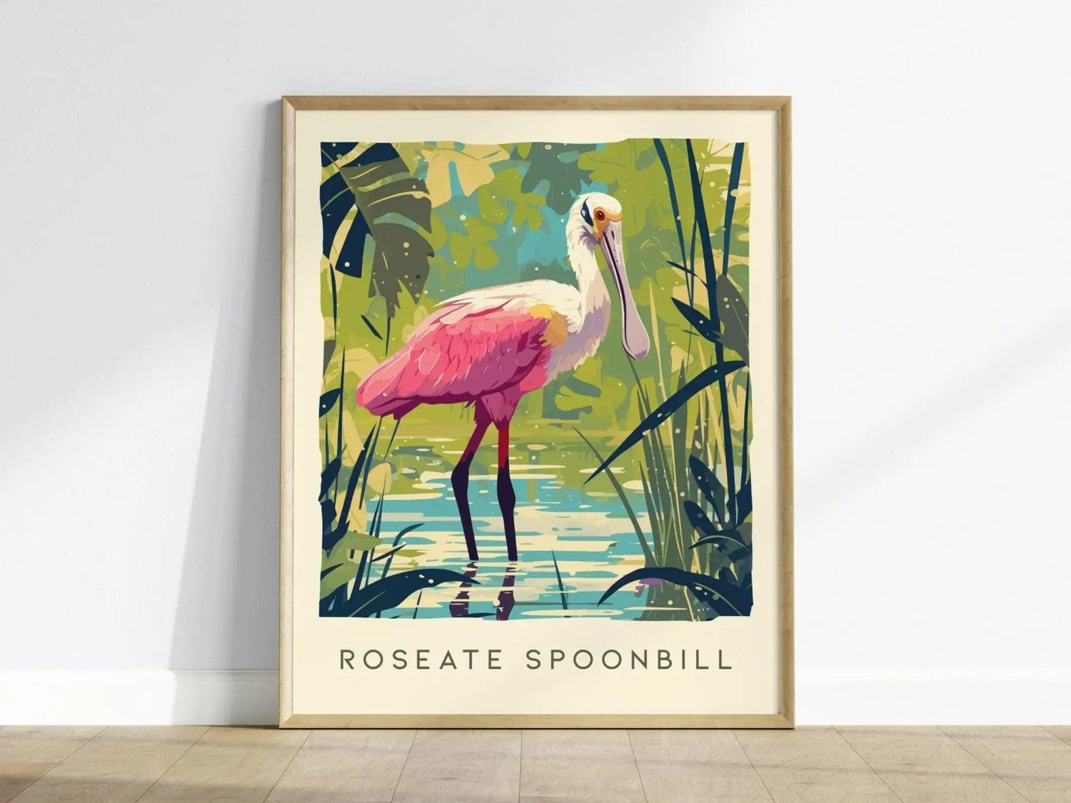 A framed poster of a Roseate Spoonbill features the bird with vibrant pink plumage standing in a lush, tropical setting. The background includes greenery and a reflective water surface, capturing the essence of its natural habitat.