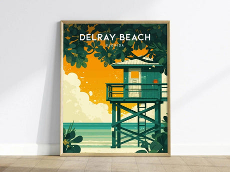 A vibrant Delray Beach poster showcases a classic wooden lifeguard stand against a backdrop of a sunset, with rich orange and green hues. Lush foliage surrounds the stand, capturing the essence of South Florida’s coastal charm.