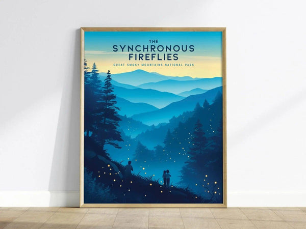 A framed poster titled The Synchronous Fireflies features a serene landscape of the Great Smoky Mountains at dusk. Silhouetted figures stand in the foreground, surrounded by glowing fireflies illuminating the tranquil scene.